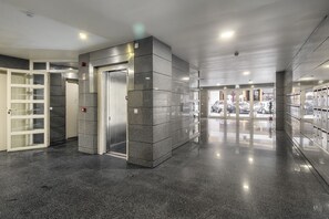Experience the sleek lobby, featuring a polished floor, central elevator, and convenient self-service lockers.