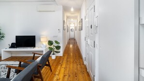 Un salon moderne avec un téléviseur à écran plat, une table basse et une plante en pot.