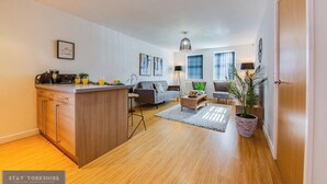 Una sala moderna con un sofá, una mesa de centro y un comedor con mostrador de cocina.