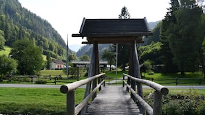 Eine Holzbrücke führt zu einem Gebäude, an dem ein Schild mit der Aufschrift 'Bubmer Ge' steht.