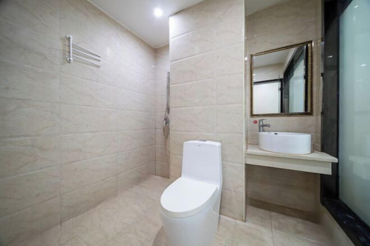 A modern bathroom with a toilet, sink, and shower.