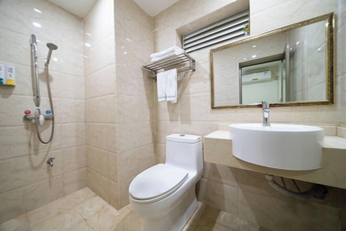 Ein Badezimmer mit Toilette, Waschbecken, Dusche und Spiegel.