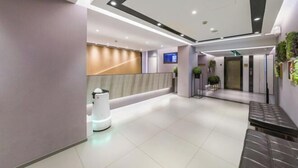 A modern hotel lobby with a reception desk, seating area, and a digital screen. - Homeinn Selected Hotel (Shanghai Convention Center Qibao Metro Station) (Shanghai)
