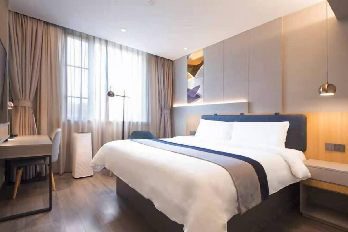 Een moderne hotelkamer met een groot bed, een bureau en een stoel.