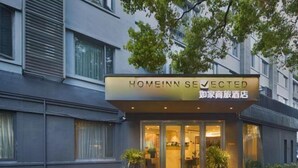A hotel entrance with a sign reading "HOMEINN SELECTED" and a Chinese translation. - Homeinn Selected Hotel (Shanghai Convention Center Qibao Metro Station) (Shanghai)