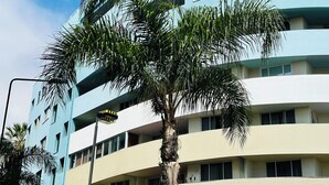 A multi-story building with a curved facade, balconies, and a visible ground floor entrance labeled "SPAR MARKET". - Lido Casa by Olá Madeira (Funchal)