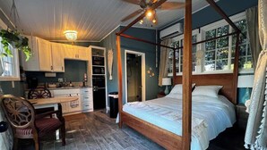 Ein Schlafzimmer mit einem Himmelbett, einem Holztisch und einem Stuhl.