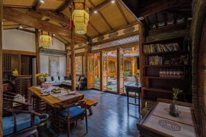 A traditional interior with a wooden table, chairs, and a bookshelf.