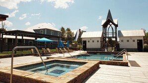 Un espace piscine doté d’une terrasse en bois, de chaises longues et d’un gazebo.