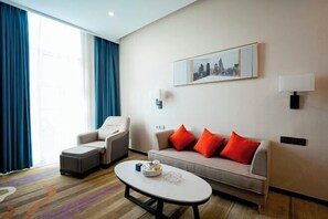 A hotel room with a sofa, armchair, ottoman, and a coffee table. - Haomei International Hotel (Anxi Government Store) (Anxi)