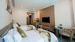 A hotel room with a large bed, a TV, a desk, and a chair. - Haomei International Hotel (Anxi Government Store) (Anxi)