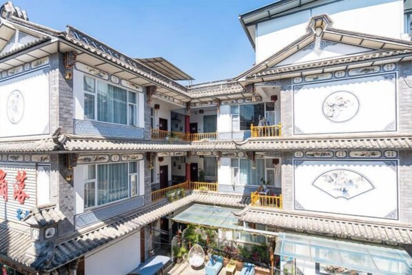 A multi-story building with traditional architectural style, featuring balconies and a courtyard.