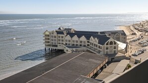 Un hotel costero con vista al mar, varias construcciones y un área de estacionamiento.
