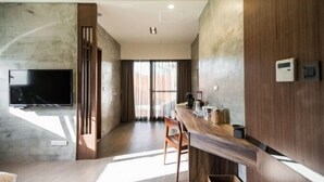 A modern kitchen with a wooden countertop, a built-in oven, and a wall-mounted television. - The Silence Manor (Hualien)