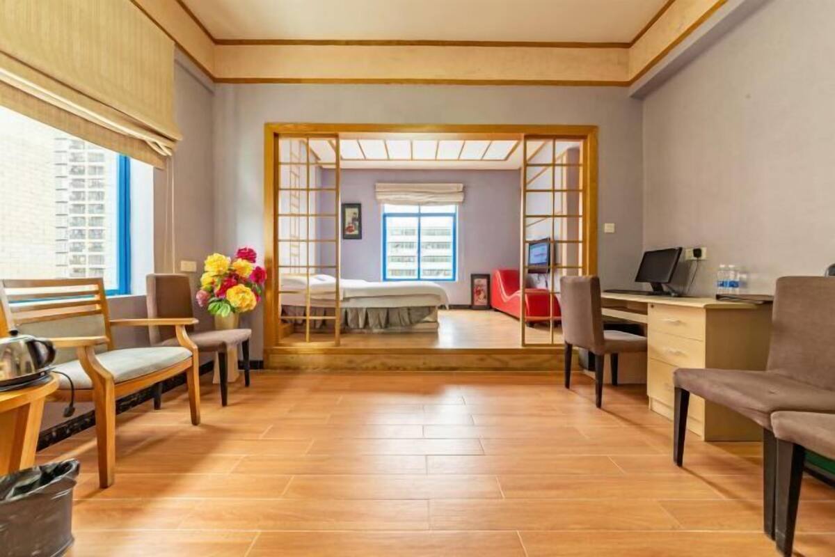 A room with a bed, a desk, a chair, a TV, and a window.