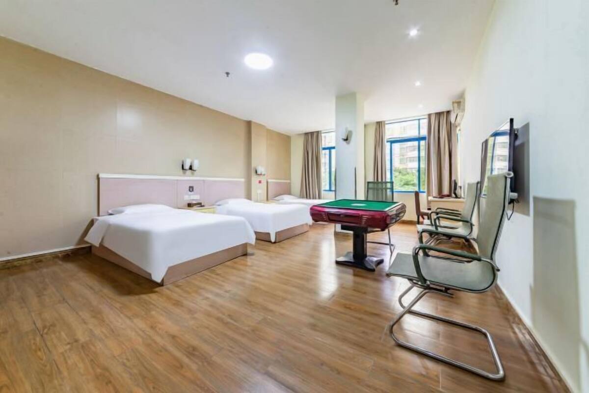 A hotel room with two beds, a pool table, and a TV.