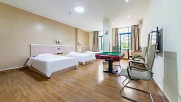 Una habitación de hotel con dos camas, una mesa de billar y un televisor.