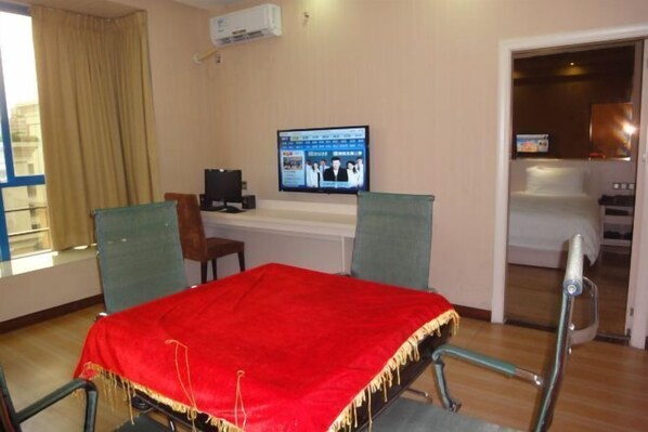 A hotel room with a bed, a television, a desk, and a chair. - Xingqiba Business Hotel Maoming (Maoming)