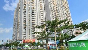 A tall residential building with multiple balconies and a clear sky. - Xingqiba Business Hotel Maoming (Maoming)