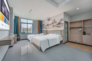 Een hotelkamer met twee bedden, een bureau, een kledingkast en een groot raam.