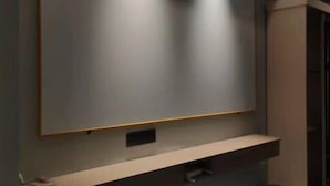 A modern bathroom with a large mirror, recessed lighting, and a built-in shelf. - Xingqiba Business Hotel Maoming (Maoming)