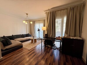 Ein modernes Wohnzimmer mit einer Couch, einem Couchtisch, einem Schreibtisch und einem Sessel.