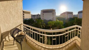 A balcony with a chair, offering a view of surrounding buildings and greenery. - Madinaty (New Cairo)