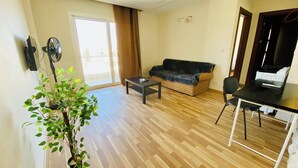 A living room with a sofa, a coffee table, a dining table, and a potted plant. - Madinaty (New Cairo)