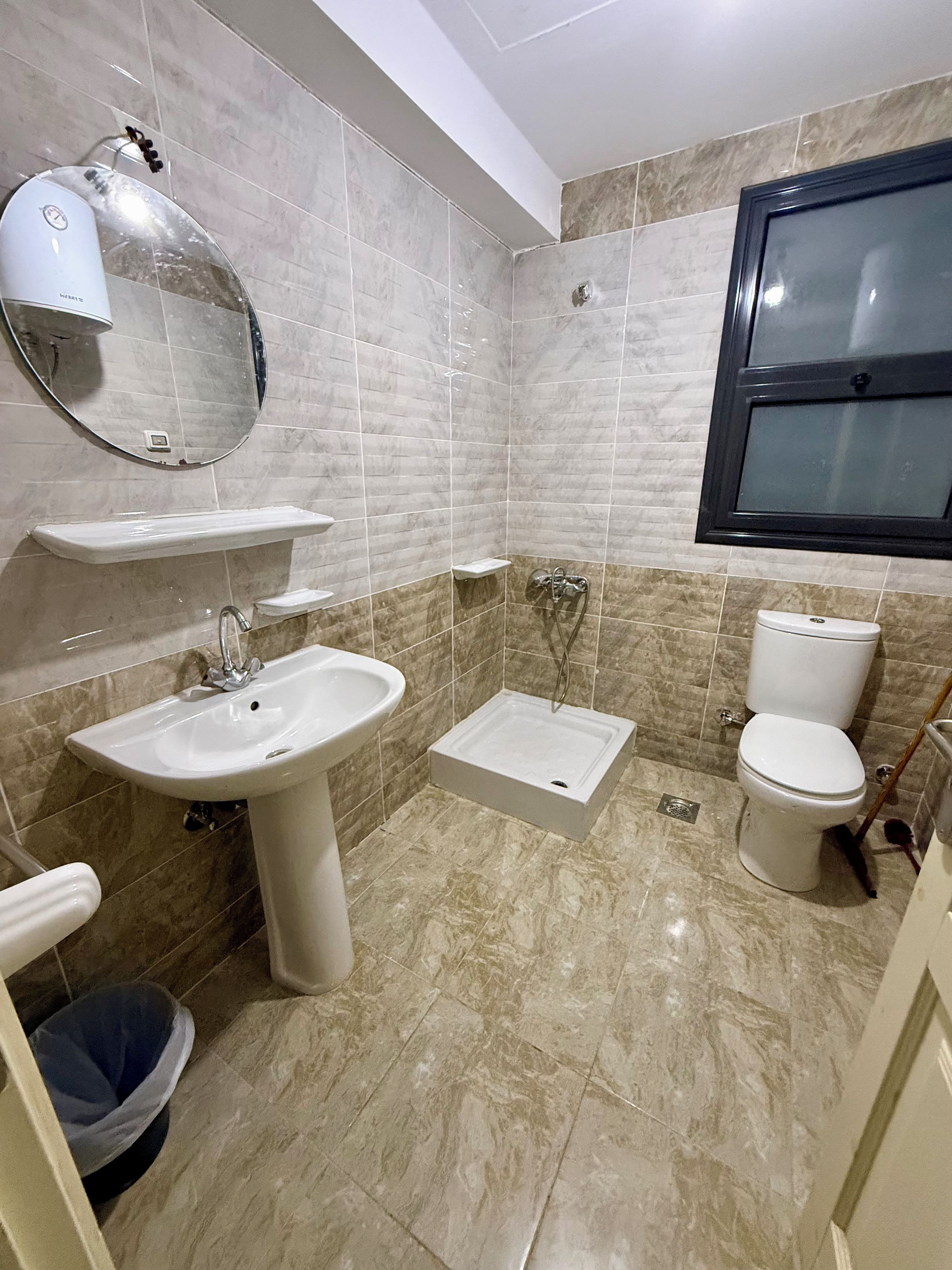 Un baño con lavamanos, espejo, inodoro y ducha.