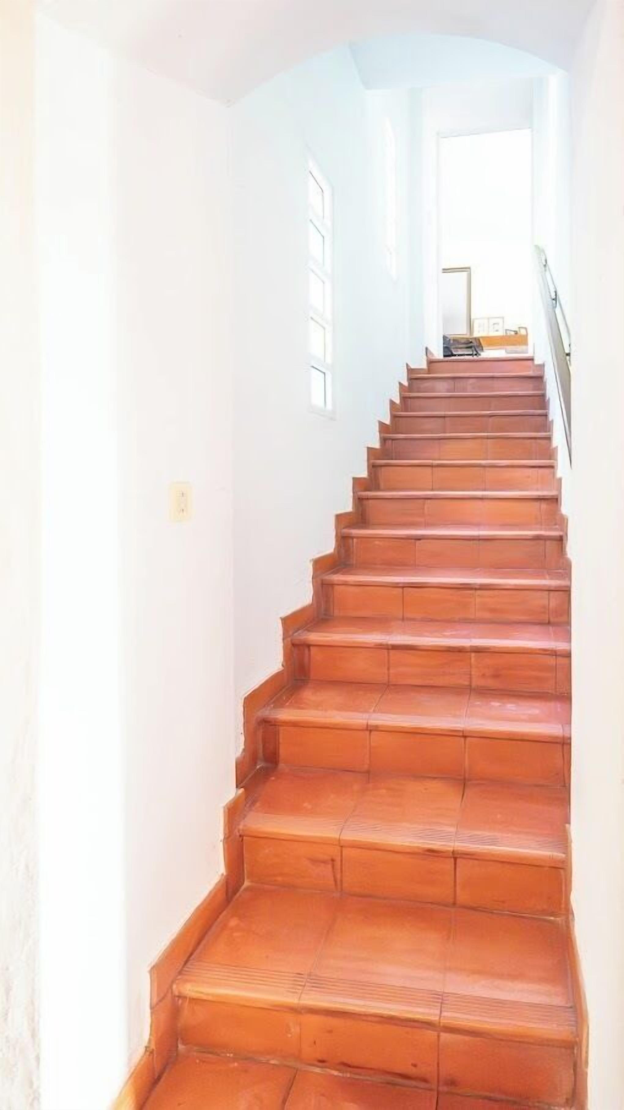 Una escalera de madera con peldaños que conducen a un rellano.