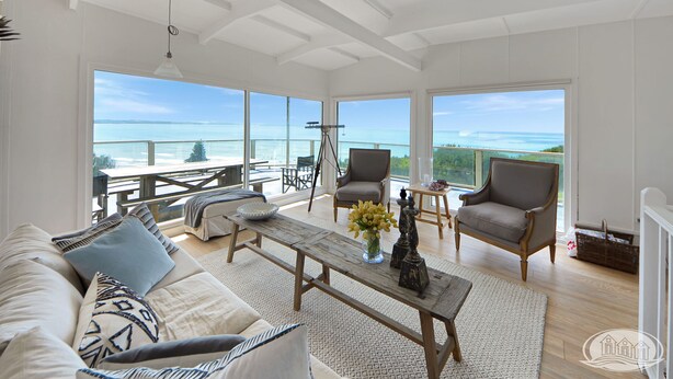 A spacious living room with a large window overlooking a scenic view, a wooden coffee table, and comfortable seating. - Breathtaking views over Bridgewater Bay (Cape Bridgewater)