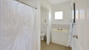 A bathroom with a toilet, sink, and shower curtain. - Breathtaking views over Bridgewater Bay (Cape Bridgewater)