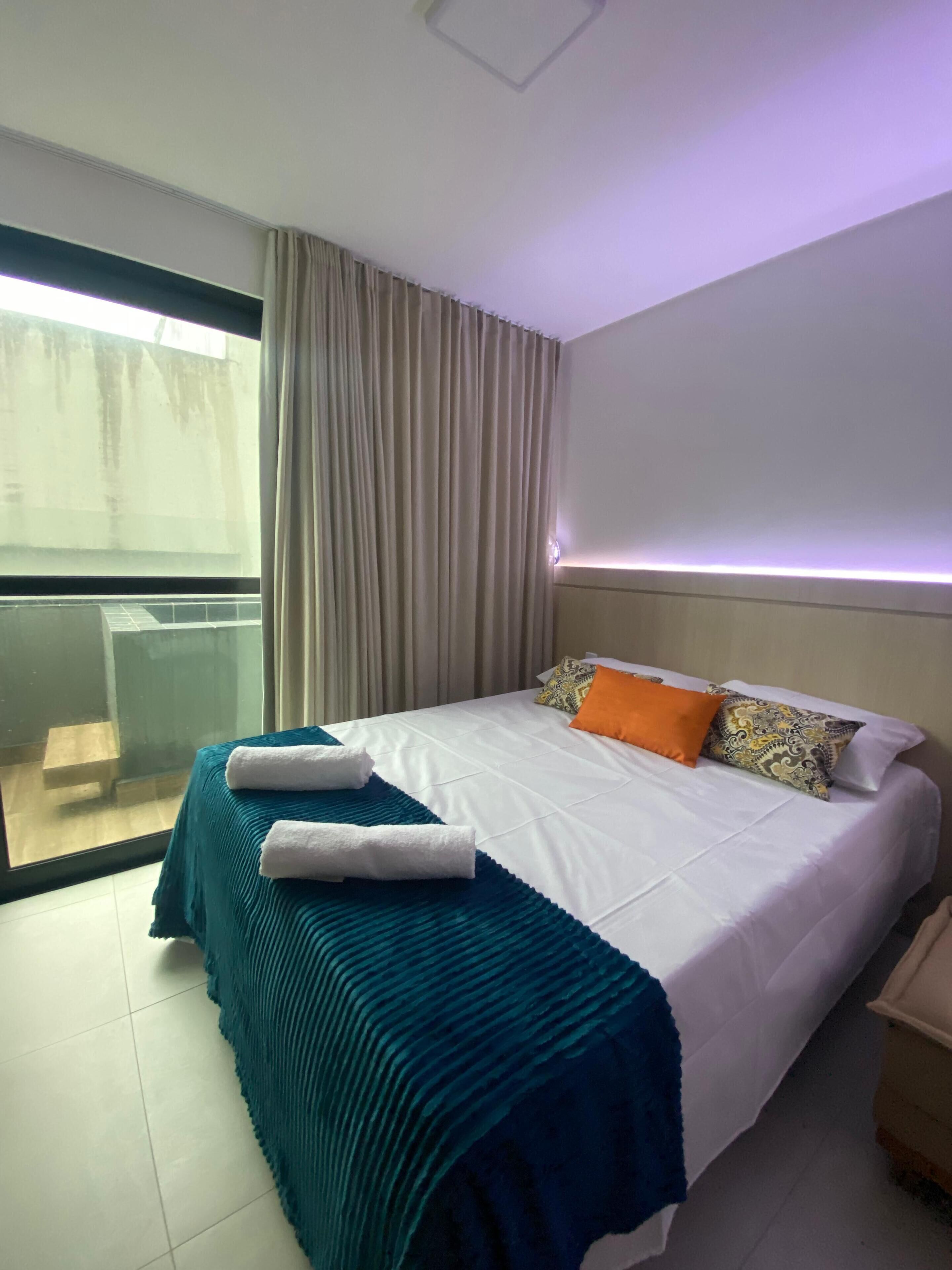 Une chambre d’hôtel avec un lit, une vue par la fenêtre et un balcon.