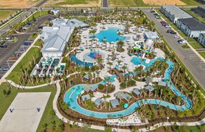Vue aérienne d’un complexe hôtelier doté d’une grande piscine centrale, de plusieurs piscines plus petites et d’un parc aquatique.