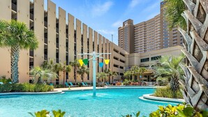 A hotel with a swimming pool, palm trees, and a large building with multiple floors. - Gulf-Front 2 Bed, 2 Bath • Sleeps 8 • Amenity-Packed • Beach Chair Service for 2 (Panama City Beach)