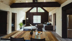 A spacious dining area with a wooden table, chairs, and a view of the living room. - Waterfront lux loft 2 bedroom perfect for couples (Pontiac)