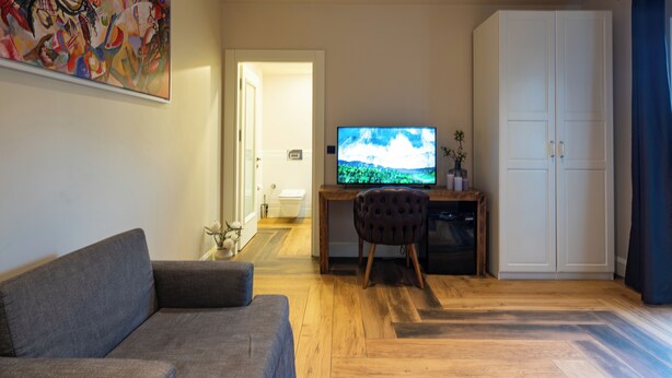 A living room with a sofa, a television, a desk with a computer, and a wardrobe. - Villa Polonez (Beykoz)