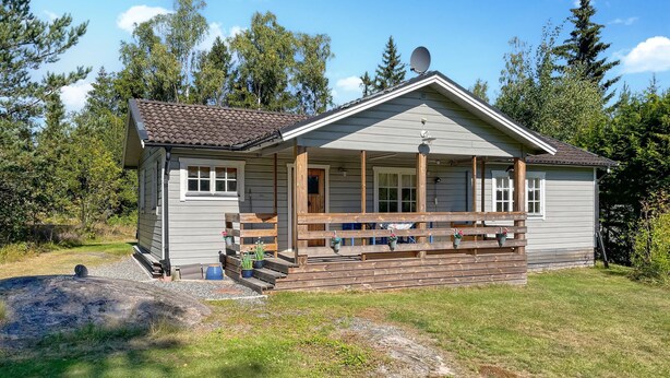 A small cabin with a porch, wooden steps, and potted plants. - 2 bedroom lovely home in Ljusterö (Ljusterö)