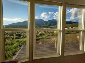 Ein Zimmer mit großem Fenster und Blick auf eine Berglandschaft.