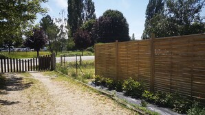 Un sendero de grava que conduce a una valla de madera con una puerta.