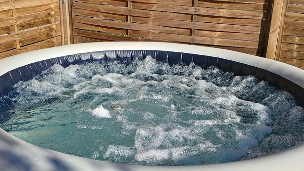 Un jacuzzi al aire libre rodeado de vallas de madera.