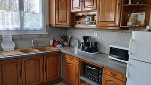 Una cocina con armarios de madera, un lavamanos, un microondas y un horno empotrado.