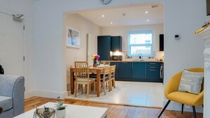 A modern apartment with a dining area, kitchen, and living room.