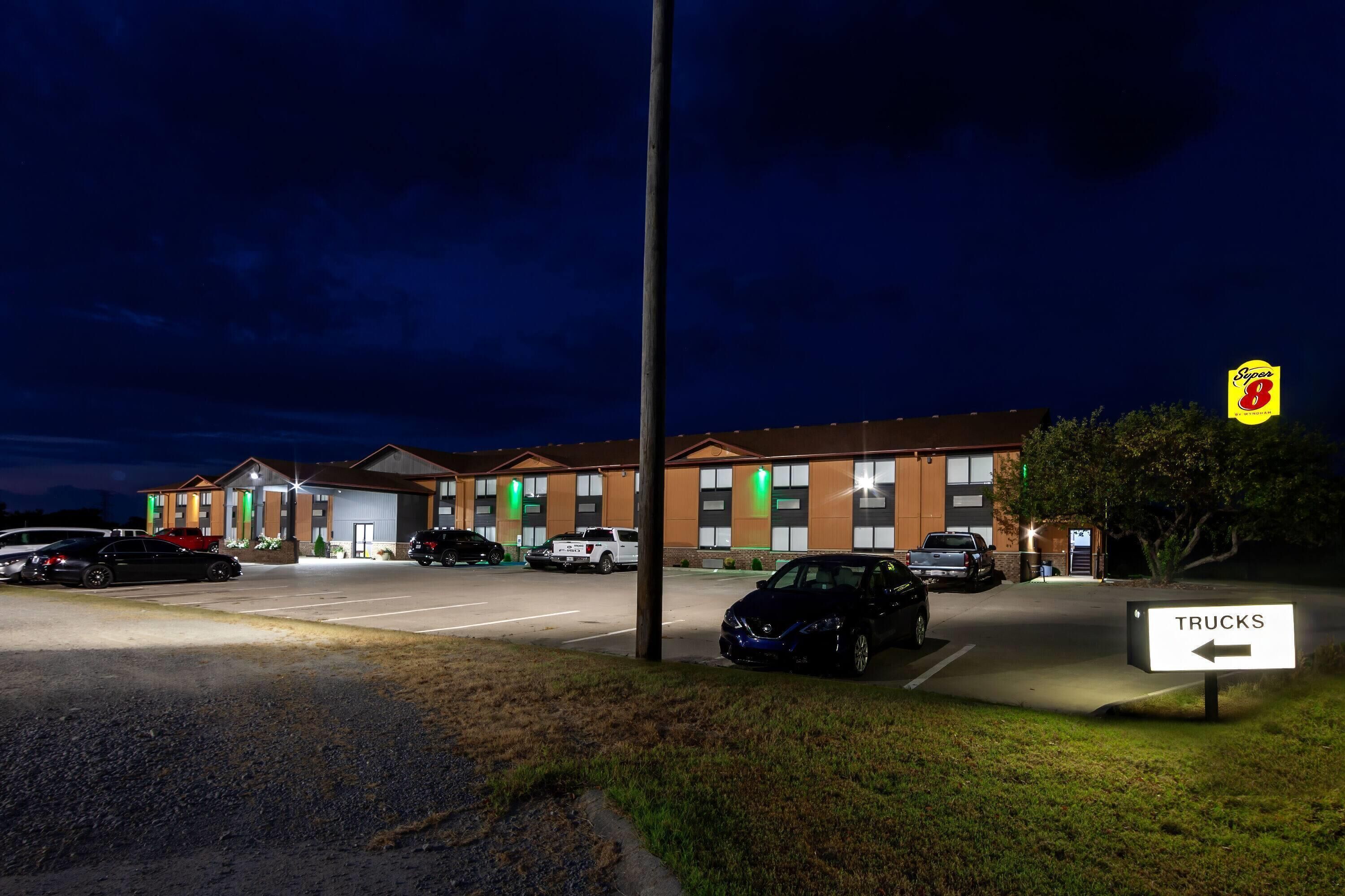 Un hôtel doté d’un parking, d’un panneau indiquant une zone de stationnement pour camions et du logo Super 8.