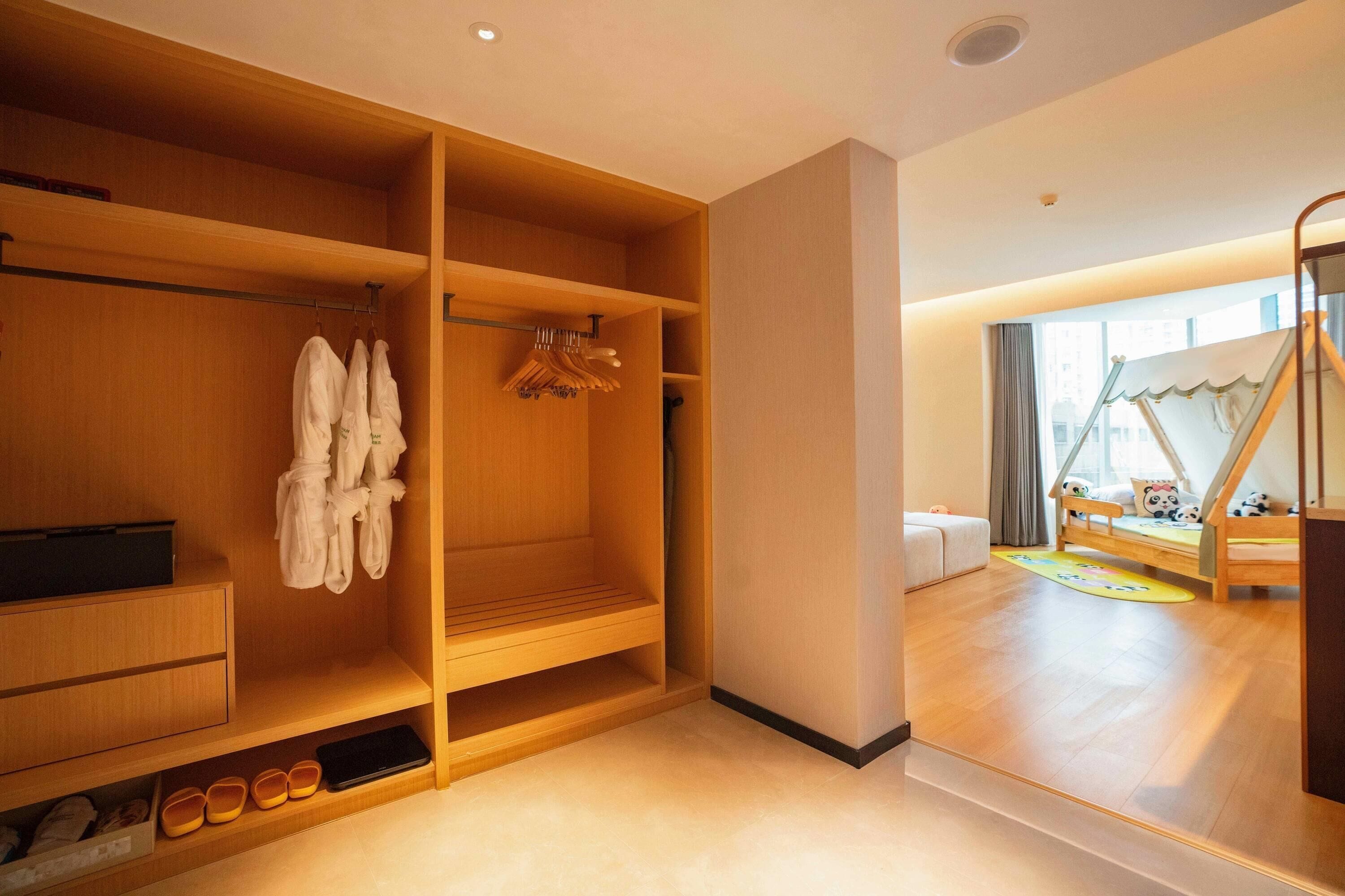 Ein modernes Zimmer mit Holzböden, einem Etagenbett und einer kleinen Spielecke.