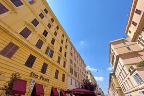 A multi-story building with a yellow facade and a sign reading 'Del Frate.'