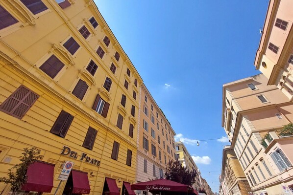 A multi-story building with a yellow facade and a sign reading 'Del Frate.'