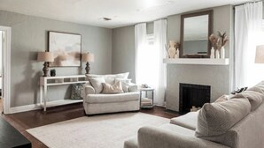 A living room with a fireplace, a sofa, a coffee table, and a side table. - 7 min to Downtown / W/D / Historic / Central (Oklahoma City)
