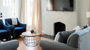 A modern living room with a flat-screen TV, two sofas, a coffee table, and a fireplace. - Perfect for Large Groups /Walkable /Plaza (Oklahoma City)