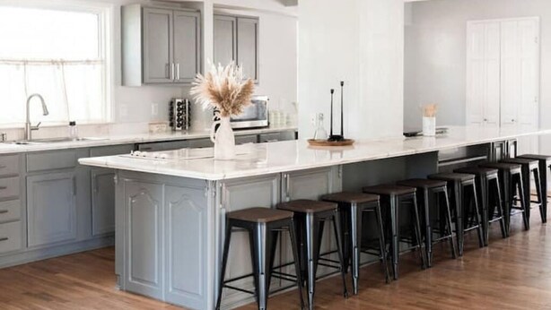 A modern kitchen with a large island, bar stools, and grey cabinetry. - Perfect for Large Groups /Walkable /Plaza (Oklahoma City)